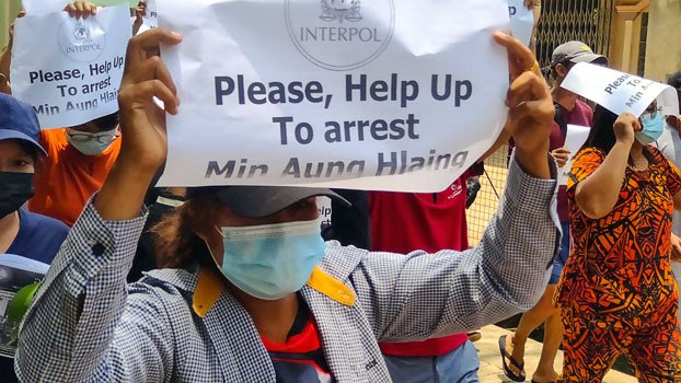 أحد المتظاهرين المناهضين للانقلاب في ميانمار يحمل إشارة تدعو إلى اعتقال رئيس المجلس العسكري الأعلى مين أونغ هلاينغ في داوي fمنطقة ثانينثاري بجنوب ميانمار في 23 أبريل 2021