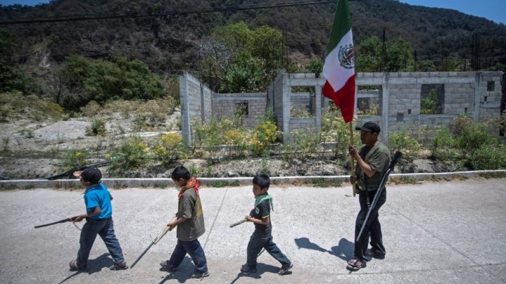 أولاد يحملون بنادق غير حقيقية ويسيرون في قرية اياهوالتمبا المكسيكية في 10 نيسان 2021