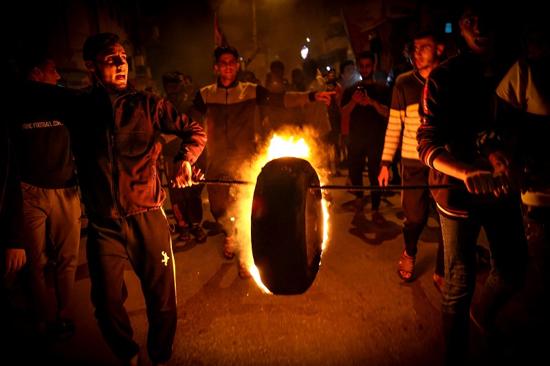 محتجون في غزة يضرمون النار في إطار