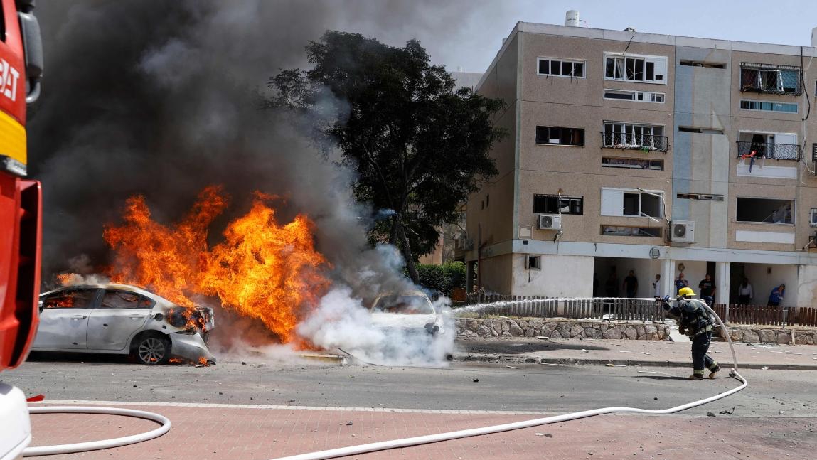 رجال الإطفاء يخمدون نيران سيارة مشتعلة بعد إطلاق حماس صواريخ من قطاع غزة الى عسقلان في جنوب إسرائيل