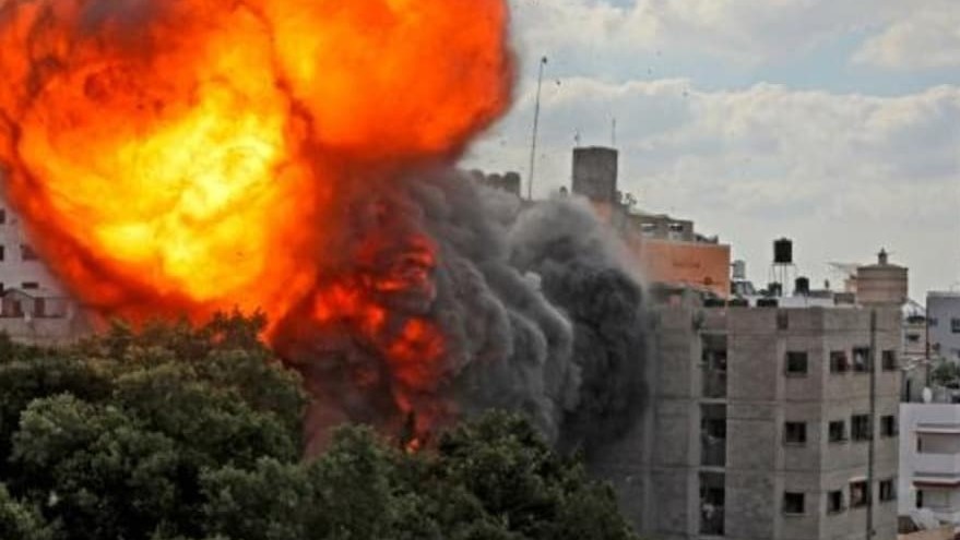  مبنى يحترق في غزة بعد إصابته في غارة إسرائيلية في 13 أيار/مايو 2021