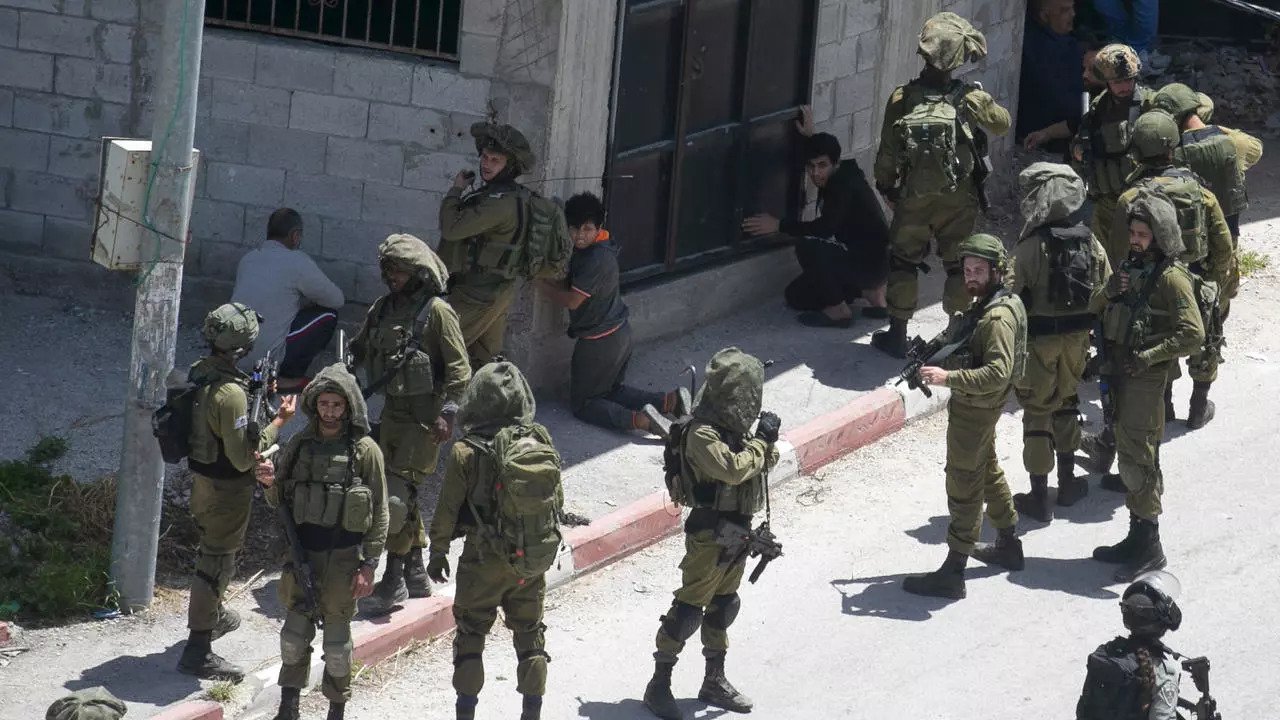 جنود إسرائيليون يعتقلون فلسطينيين في قرية 