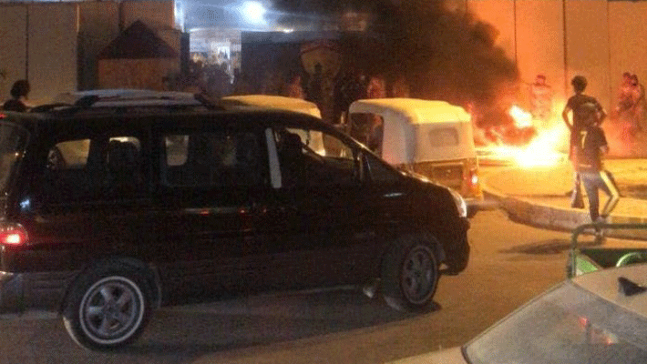محتجون يضرمون النار ليل الاحد في محيط القنصلية الايرانية في كربلاء