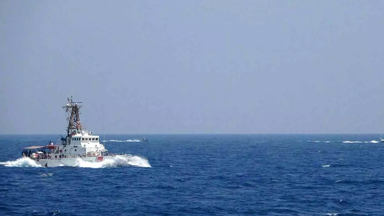 صورة وزعتها البحرية الأميركية في 10 أيار/مايو 2021، تظهر في خلفيتها قطعتان بحريتان إيرانيتان على مقربة من سفينة أميركية في مضيق هرمز