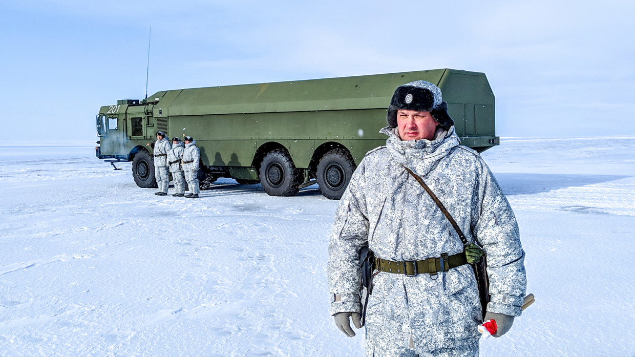 ضابط روسي وجنود يقفون بجانب شاحنة عسكرية في القاعدة العسكرية الروسية الشمالية في جزيرة كوتيلني، خلف الدائرة القطبية الشمالية في 3 أبريل 2019