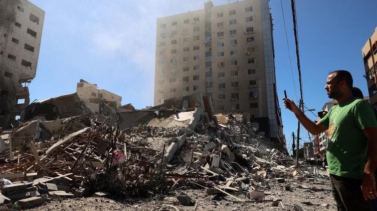 مواطن فلسطيني يوثق بالصورة مبنى قصفته إسرائيل في غزة
