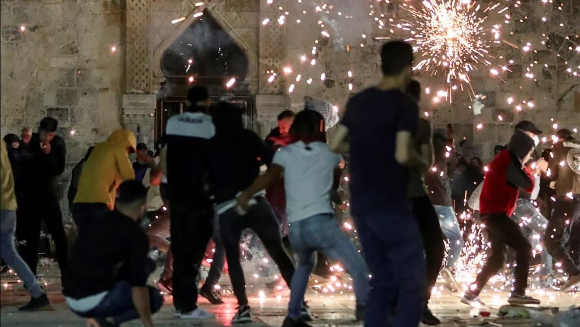 لشرطة الإسرائيلية تلقي قنابل الصوت على فلسطينيين خلال اشتباكات في المجمع الذي يضم المسجد الأقصى في 7 مايو 2021
