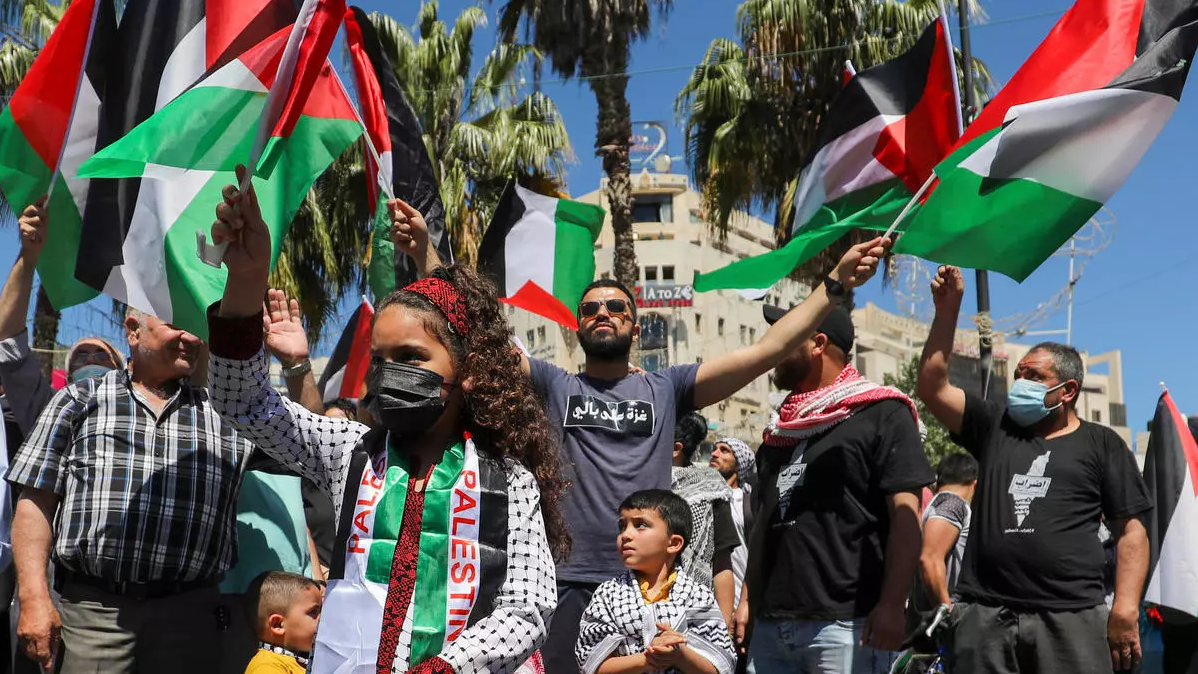 متظاهرون فلسطينيون يحملون العلم الفلسطيني وسط مدينة رام الله