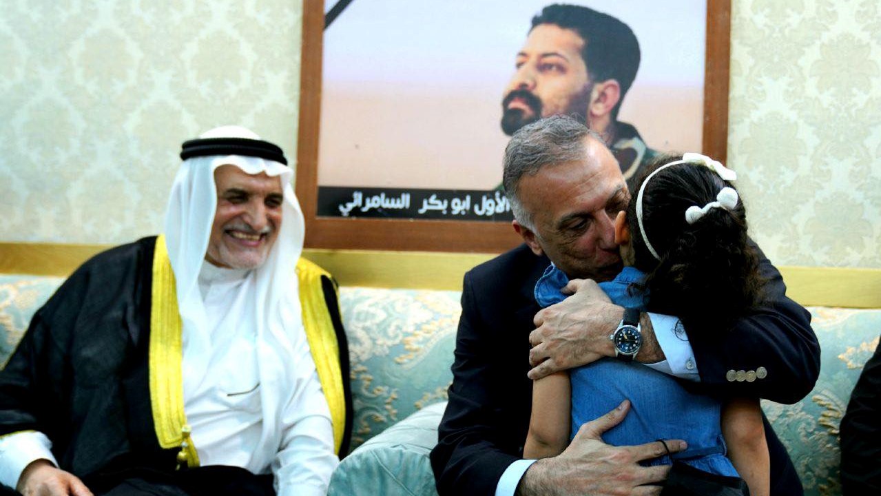 الكاظمي محتضنا ابنة ضابط عراقي اعدمه داعش