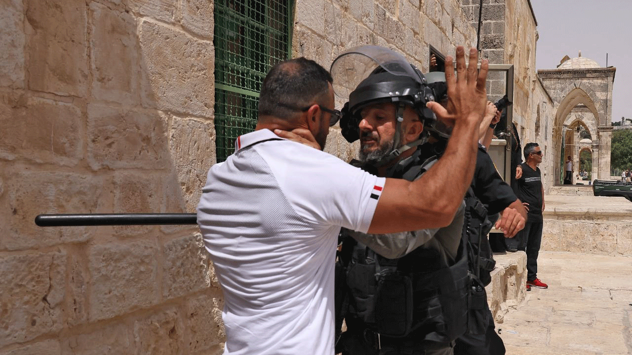 فلسطيني خلال مواجهة مع عنصر من القوات الامن الاسرائيلية في المسجد الأقصى بالقدس (21 ايار/مايو 2021