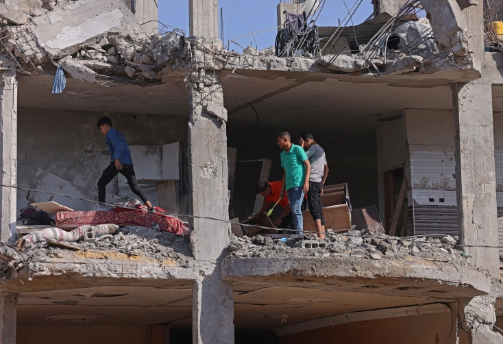 مواطنون يعاينون منزلهم الذي دمره القصف الاسرائيلي