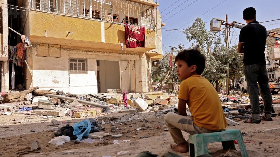 طفل يجلس على أنقاض منزل دمرته إسرائيل