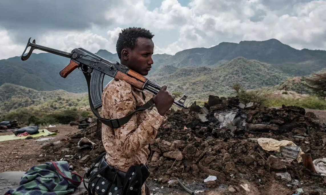 أحد أفراد القوات الخاصة في عفار أمام أنقاض منزل في ضواحي قرية بيسوبر في منطقة تيغراي في إثيوبيا