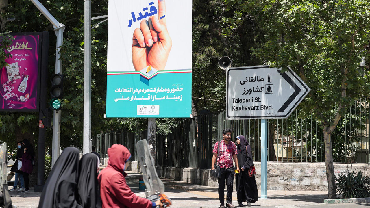 ايرانيون يمرون أمام لافتة انتخابية في العاصمة طهران في 29 أيار/مايو 2021