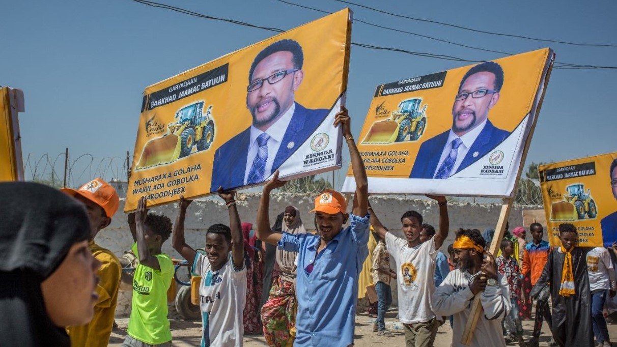 أشخاص يرفعون صور مرشحين لانتخابات أرض الصومال خلال تجمع لحزب 