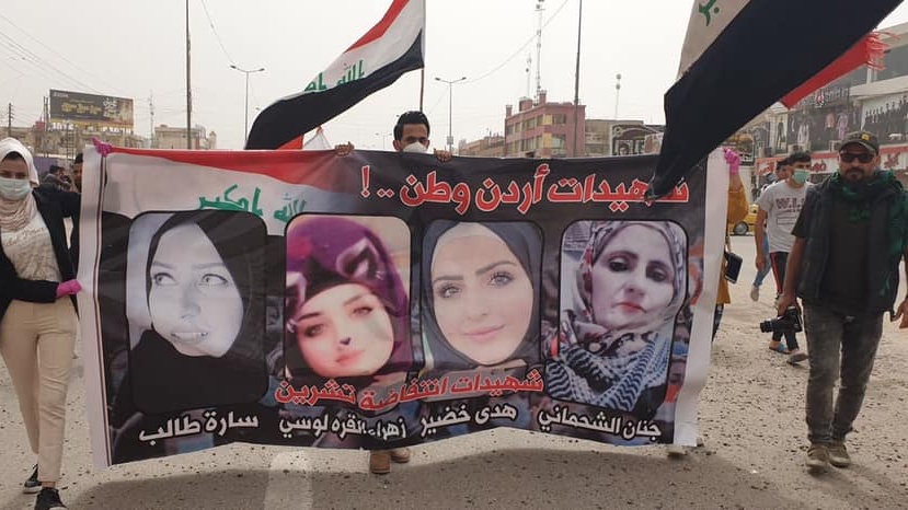 محتجون عراقيون يرفعون صورا لمتظاهرات قتلتهن مليشيات موالية لايران