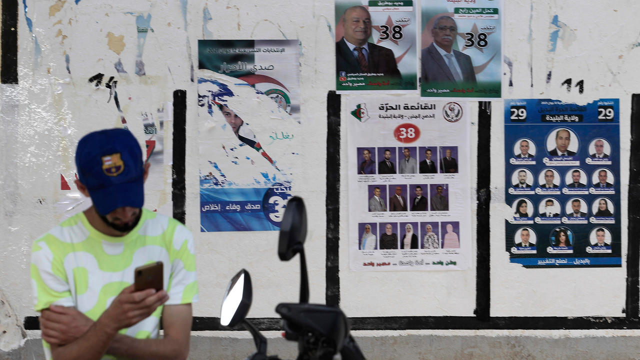 صورة مؤرخة في 31 أيار/مايو 2021 تظهر شابا امام ملصقات انتخابية في الجزائر العاصمة 
