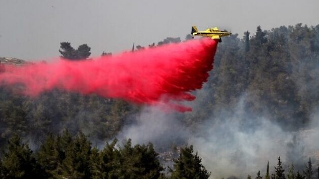طائرة إطفاء تعمل على إخماد حريق غابة في منطقة قرية أبو غوش بالقرب من القدس- 9 يونيو 2021