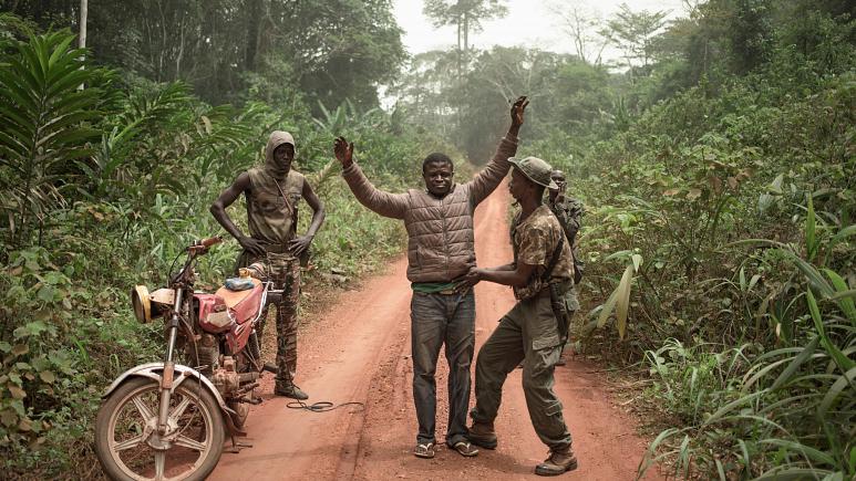 حراس مسلحون يفتشون شابا سائق تاكسي دراجة في بيانغا بجمهورية إفريقيا الوسطى في 14 مارس 2020