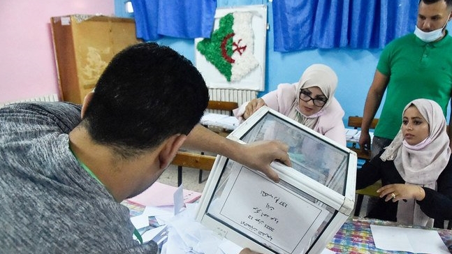 موظفو الانتخابات الجزائرية يقومون بفرز الأصوات للانتخابات البرلمانية في مركز اقتراع في بوشاوي، في الضواحي الغربية للعاصمة الجزائر. 12 حزيران/ يونيو 2021