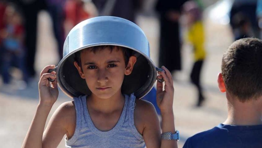 طفل سوري ينتظر المساعدات الإنسانية
