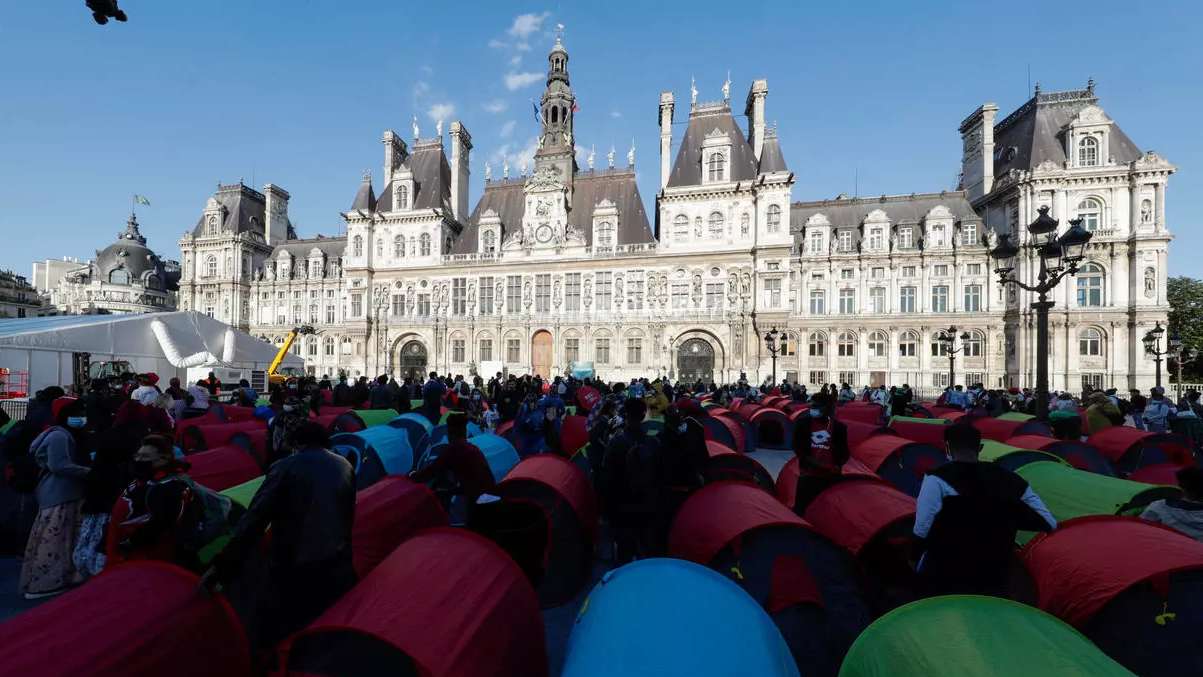 مهاجرون مشردون وداعمون لهم ينصبون خيماً أمام بلدية باريس في 24 حزيران/يونيو 2021