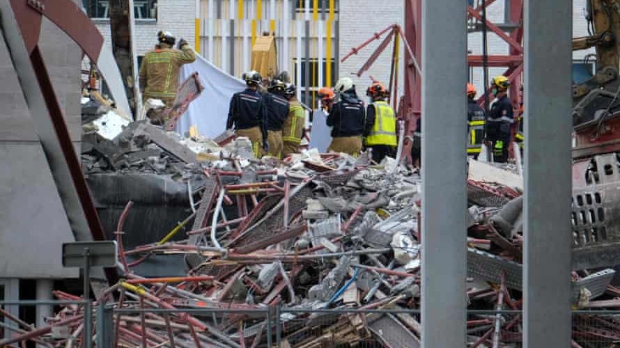 عمّال الإنقاذ يبحثون بين الأنقاض بعد انهيار جزئي لمبنى مدرسة قيد الإنشاء في مدينة انتويرب ببلجيكا السبت 19 حزيران/يونيو 2021.