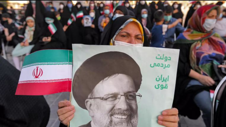 سيدة ترفع صورة الرئيس الإيراني المنتخب إبراهيم رئيسي خلال تجمع لمناصريه في طهران في 19 يونيو 2021