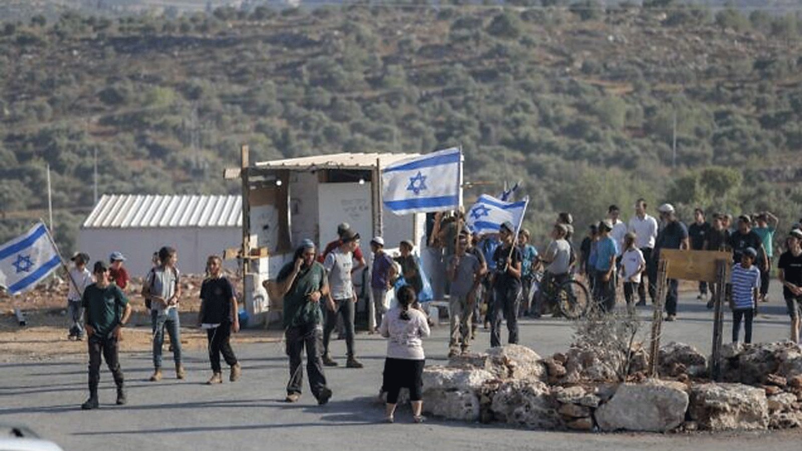 المستوطنون الإسرائيليون يسيرون بالأعلام في بؤرة أفيتار الاستيطانية غير الشرعية في الضفة الغربية. 21 حزيران/ يونيو 2021 
