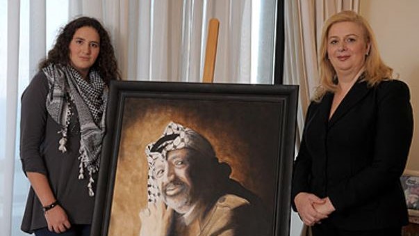 سهى عرفات وابنتها مع صورة الرئيس الفلسطيني الراحل ياسر عرفات