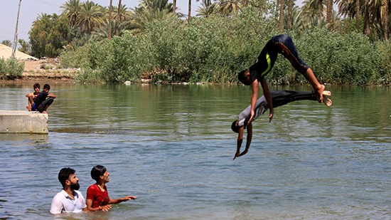 عراقيون يواجهون ارتفاع درجات الحرارة بالسباحة في أنهار بلدهم