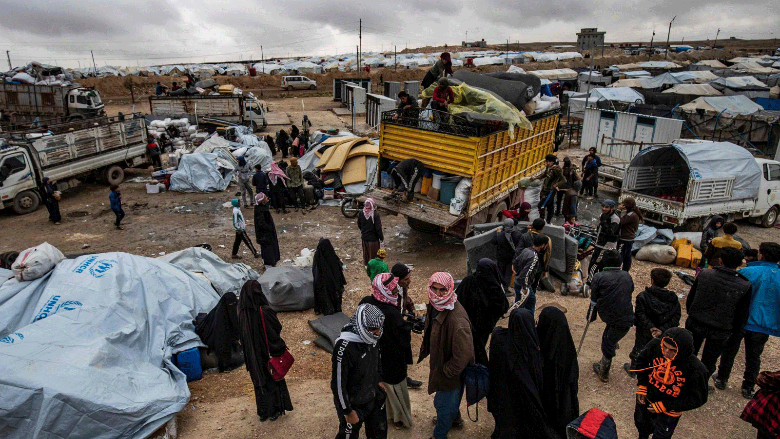 سوريون يقومون بتحميل متعلقاتهم في شاحنات أثناء استعدادهم لمغادرة مخيم الهول الذي تديره وحدات حماية الشعب، والذي يحتجز أقارب مقاتلين مزعومين من داعش، في محافظة الحسكة شمال شرق سوريا، 16 تشرين الثاني/ نوفمبر2020