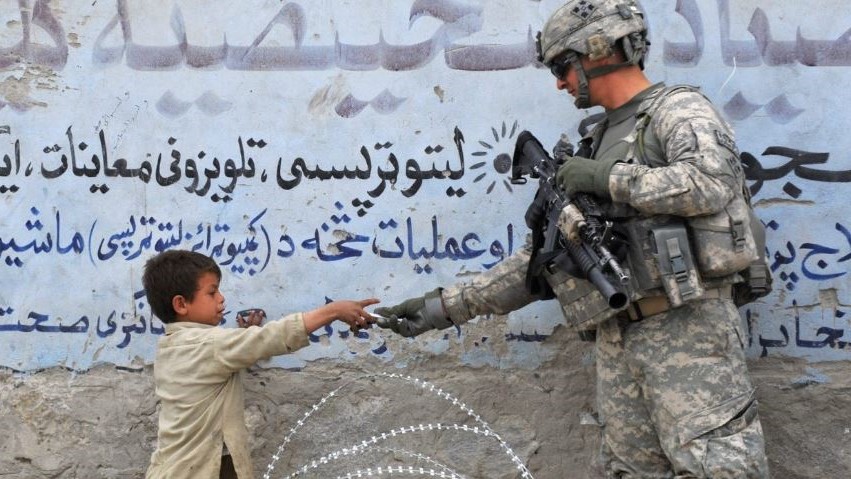 صورة من الأرشيف لجندي أميركي يقدم هدية لطفل أفغاني