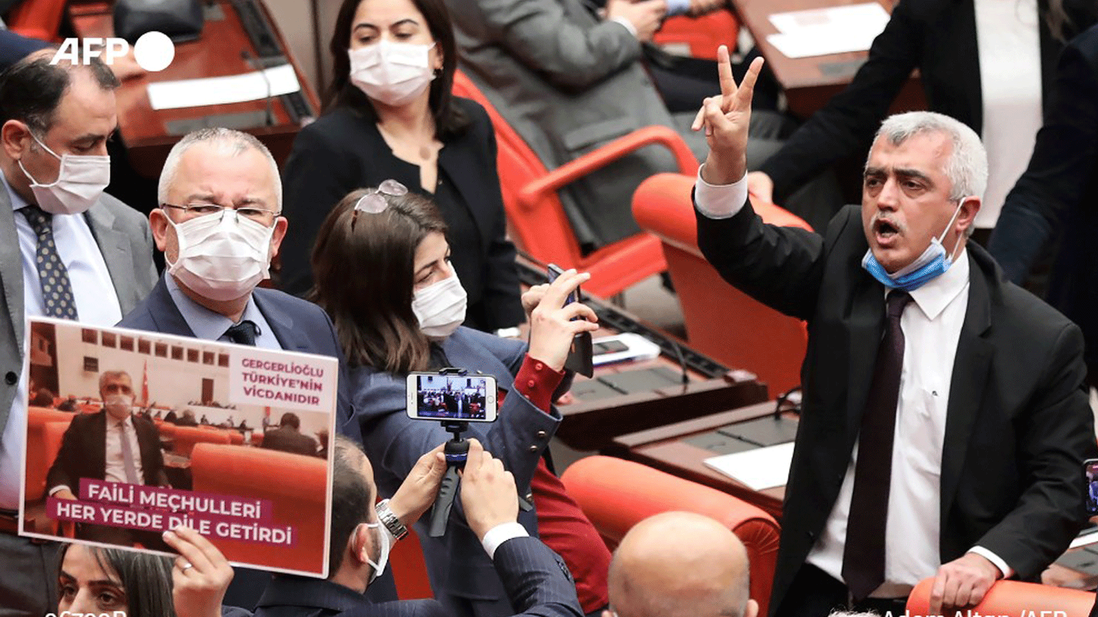 عمر فاروق جرغيرلي أوغلو، عضو البرلمان التركي عن حزب الشعوب الديمقراطي، وهو محاط بمشرعين يصفقون ويلوحون باللافتات بعد إقالته من خلال التصويت في البرلمان التركي في أنقرة، بتاريخ 17 آذار/مارس 2021