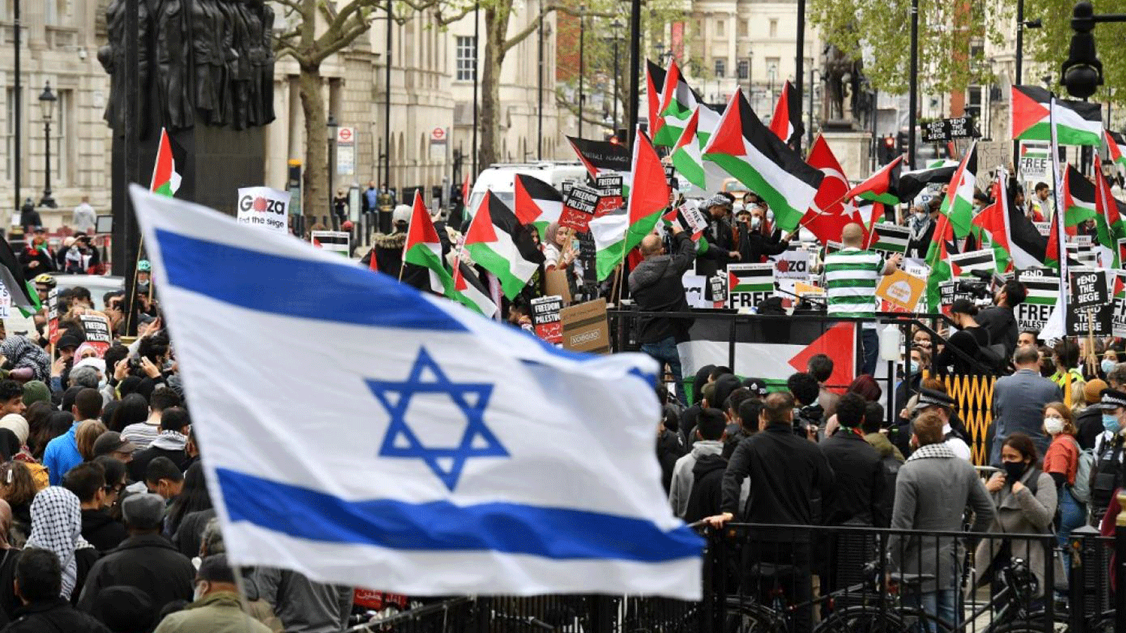 نشطاء مؤيدون لإسرائيل يلوحون بالعلم الإسرائيلي بينما يتظاهر النشطاء المؤيدون للفلسطينيين ضد الهجمات الإسرائيلية الأخيرة على الفلسطينيين، في وسط لندن في 11 مايو 2021