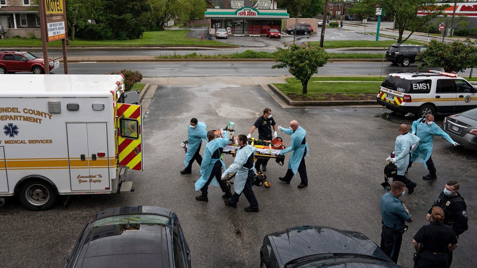 رجال الإطفاء والمسعفون يرتدون معدات الوقاية الشخصية أثناء نقلهم لمريض توقف قلبه بنتيجة تناول جرعة زائدة من المخدرات في 6 مايو 2020 في بروكلين ، ماريلاند.