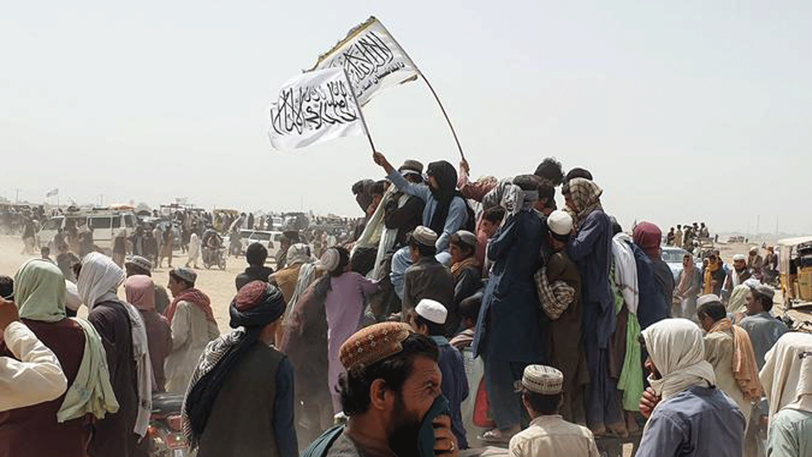 أشخاص يلوحون بأعلام طالبان أثناء مرورهم بسياراتهم عبر بلدة شامان الحدودية الباكستانية