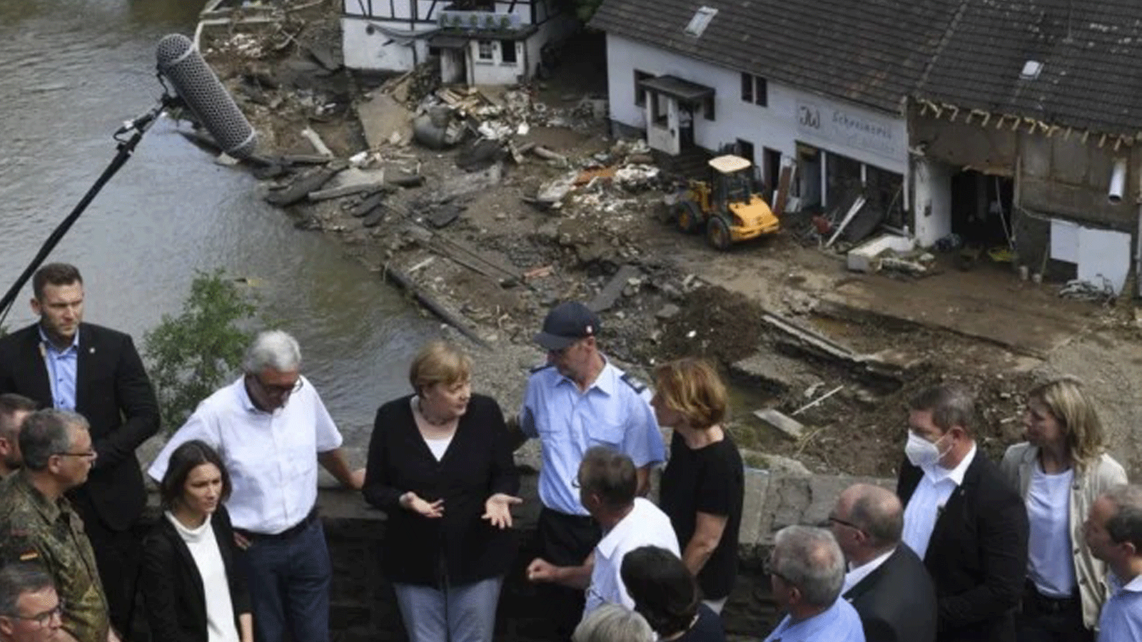 المستشارة الألمانية أنجيلا ميركل ورئيس وزراء ولاية راينلاند بالاتينات مالو دراير يتحدثان على جسر خلال زيارتهما في المناطق التي دمرتها الفيضانات في شولد، بالقرب من باد نوينار-أرويلر، ولاية راينلاند بالاتينات، غرب ألمانيا. 18 تموز/ يوليو 2021