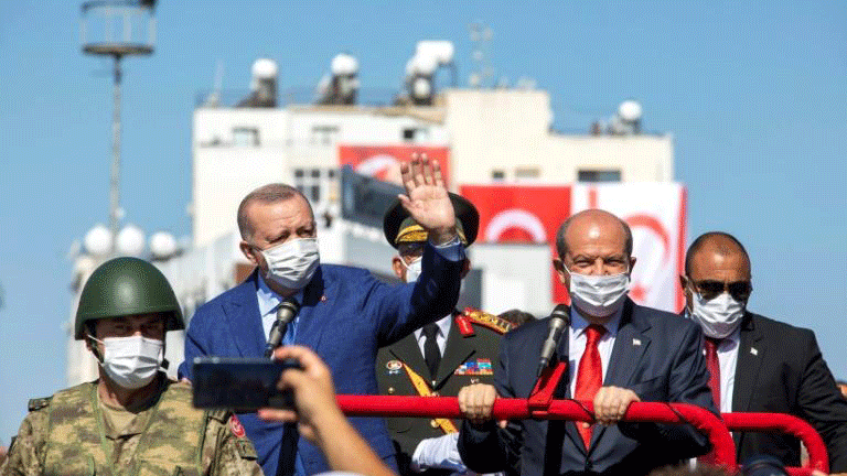 الرئيس التركي رجب طيب إردوغان وإلى يساره زعيم القبارصة الأتراك إرسين تتار خلال عرض عسكري في الشطر الشمالي من نيقوسيا بتاريخ 20 تموز/يوليو 2021