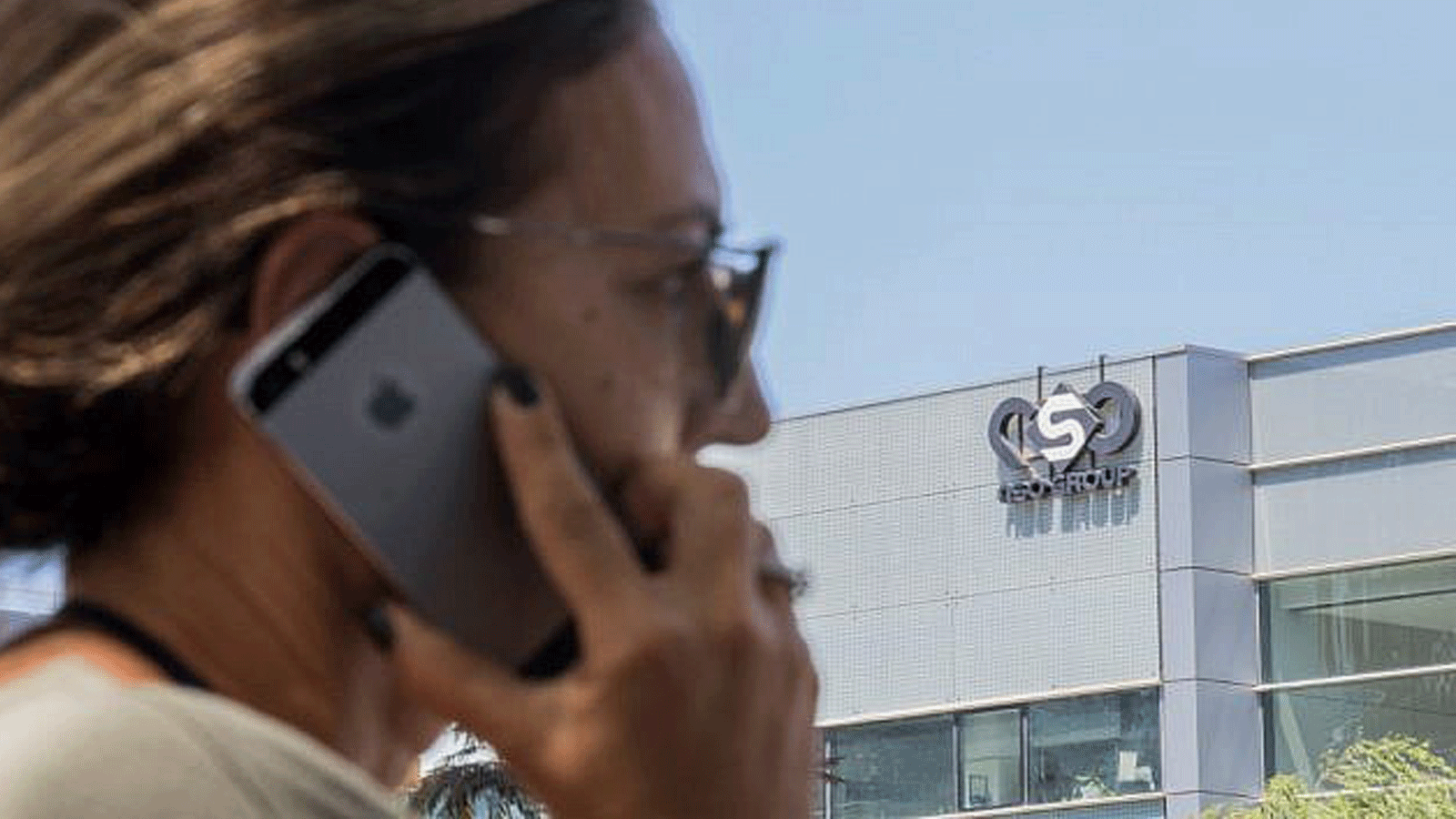 امرأة تستخدم هاتفها أمام مبنى في هرتسليا يضم شركة NSO Group للاستخبارات، 28 آب/أغسطس 2016