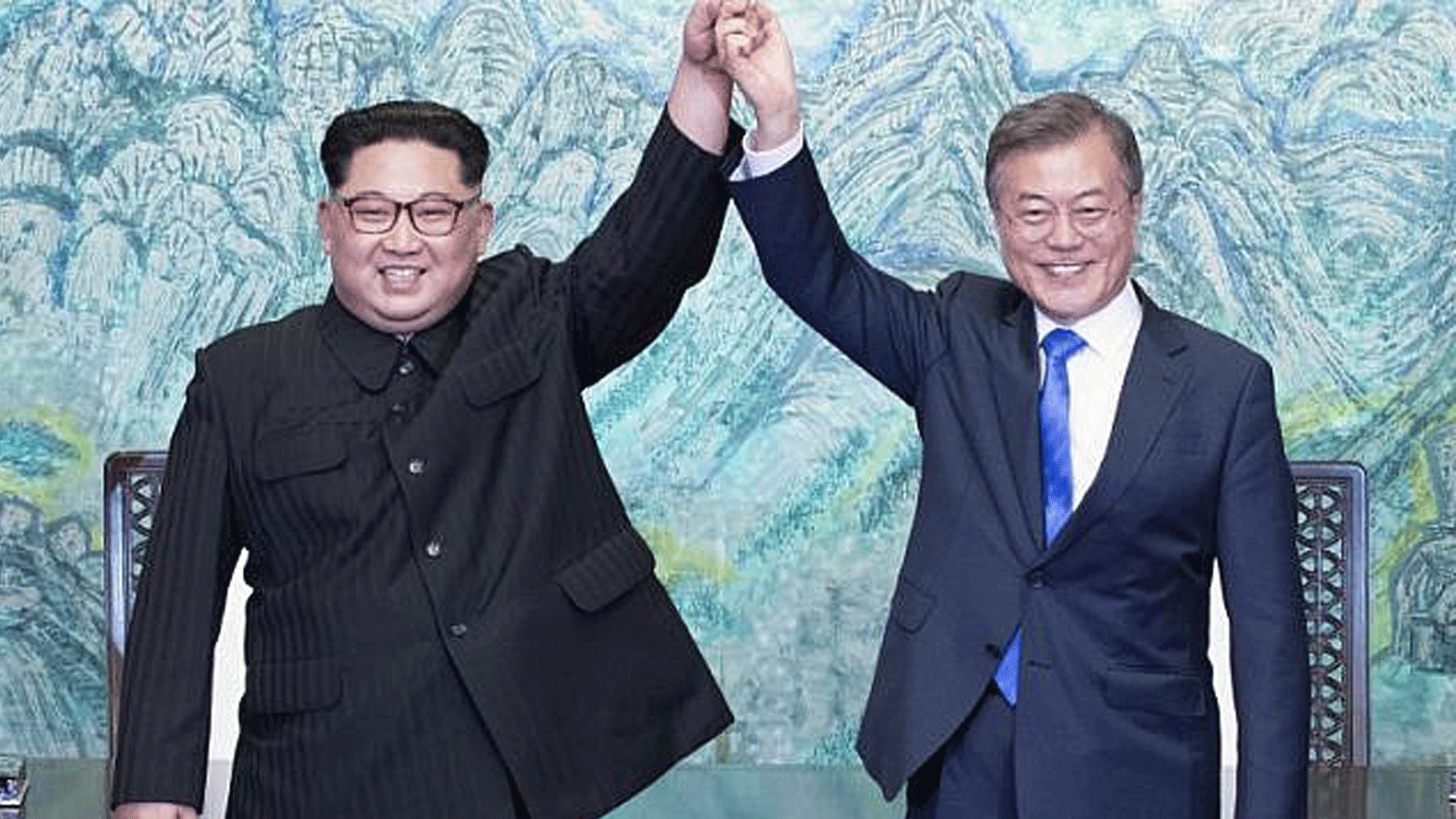 زعيم كوريا الشمالية كيم جونغ أون (إلى اليسار) ورئيس كوريا الجنوبية مون جاي إن (يمين) يرفعان أيديهما خلال حفل توقيع قرب نهاية قمتهما التاريخية في قرية الهدنة بانمونجوم في 27 نيسان/ أبريل 2018