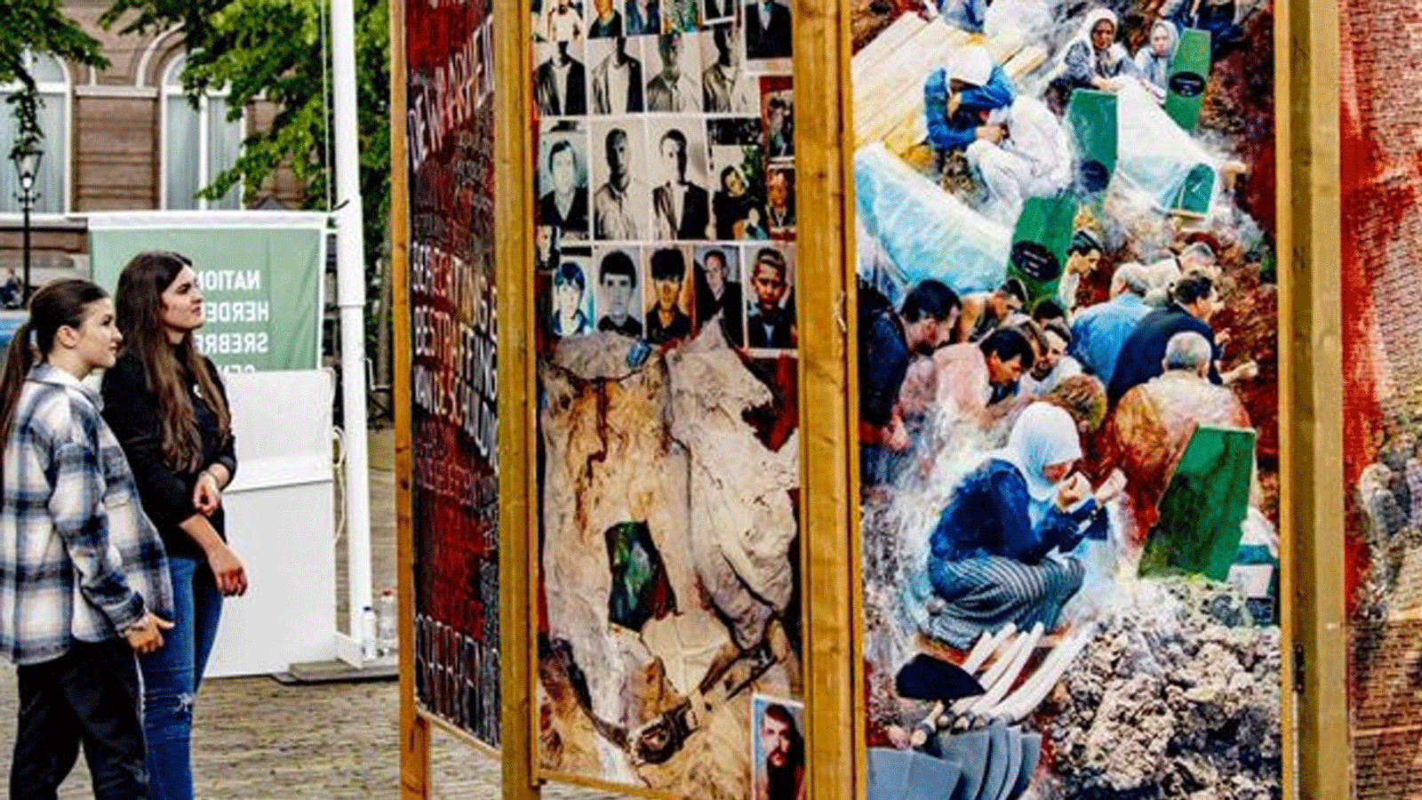 أشخاص ينظرون إلى اللوحات التذكارية، خلال إحياء الذكرى الوطنية للإبادة الجماعية في سريبرينيتشا، في لاهاي، في الذكرى 26 لمذبحة سبرينيتشا. بتاريخ 11 تموز/ يوليو 2021