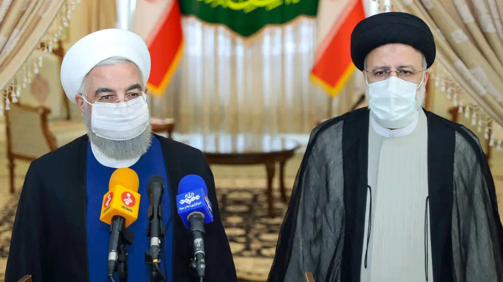 الرئيس المنتهية ولايته حسن روحاني (إلى اليسار) يشارك في مؤتمر صحفي مع الرئيس المنتخب إبراهيم رئيسي