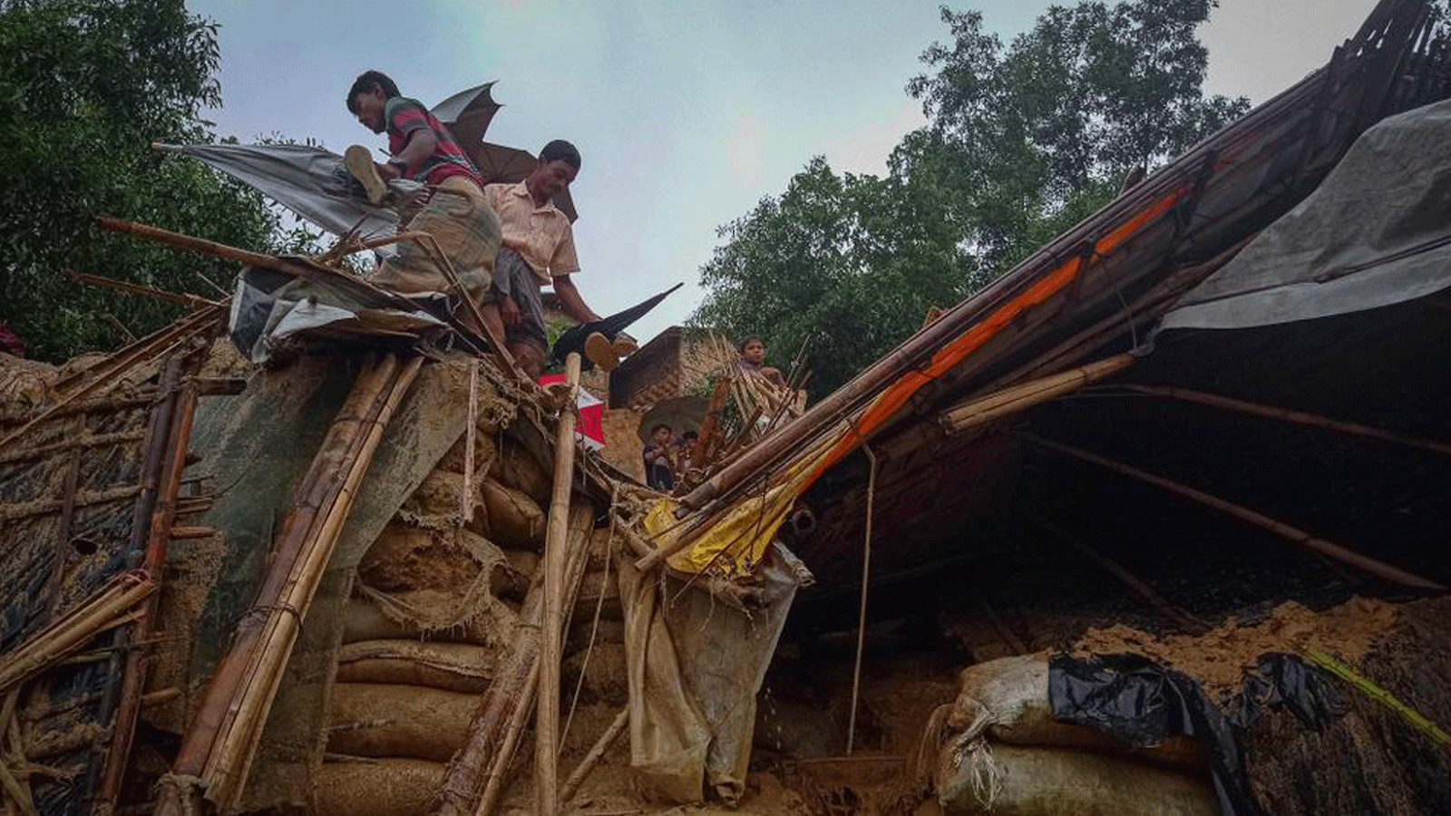 لاجئون من الروهينغا يعملون وسط حطام منزل في مخيم بالوخالي في بنغلاديش في 27 يوليو/ تموز 2021