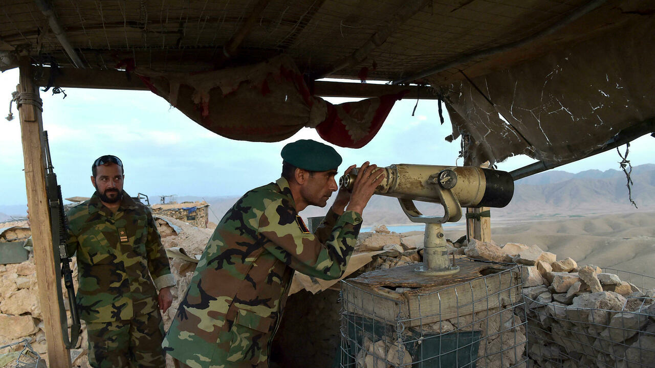 قائد الجيش الوطني الأفغاني (ANA)، دوست نزار أندارابي، يراقب بمنظار في موقع أقيم ضد مقاتلي طالبان في كاجاكي، شمال شرق مقاطعة هلمند