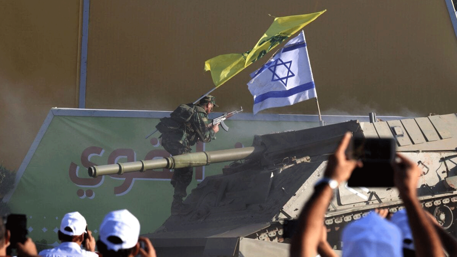 أعضاء في حزب الله الشيعي اللبناني يقومون بإعادة تمثيل هجوم على دبابة إسرائيلية بمناسبة الذكرى 11 لانتهاء حرب 2006 مع إسرائيل، في قرية الخيام في جنوب لبنان. 13 آب/أغسطس، 2017 