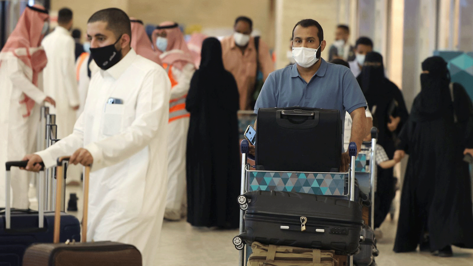 مسافرون سعوديون يصلون إلى مطار الملك خالد الدولي في العاصمة الرياض حيث رفعت السلطات السعودية قيود السفر للمواطنين المحصنين ضد كوفيد -19 ، الرياض، المملكة العربية السعودية، 17 أيار/مايو 2021
