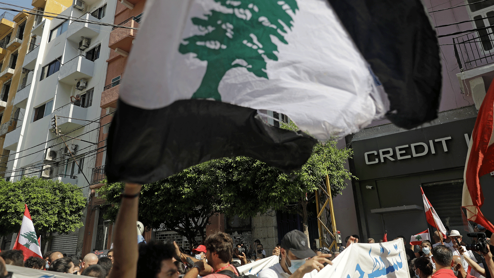 متظاهرون يرفعون الأعلام اللبنانية في حي الجميزة وهم يتجهون نحو ميناء العاصمة اللبنانية. 4 آب/أغسطس 2021