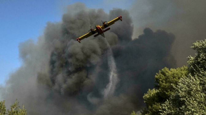 طائرة ترمي مياهًا على الحرائق قرب العاصمة اليونانية أثينا