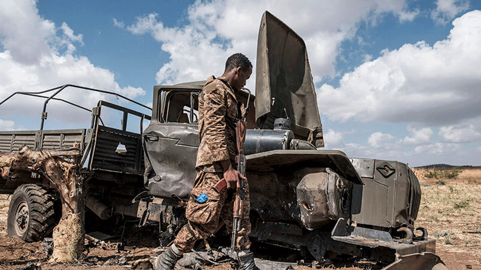 أحد عناصر قوات الدفاع الإثيوبية يتفقد شاحنة عسكرية متضررة متروكة على طريق قرب قرية أياسو جبريل شرقي مدينة ألاماتا الإثيوبية